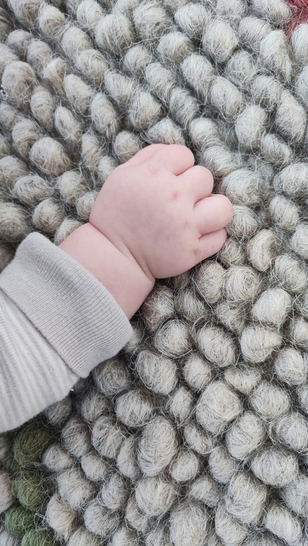 Close-up of the handwoven wool texture of the Buzhok rug