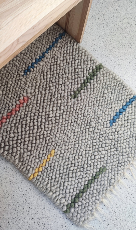Buzhok Gray Rainbow Kids Rug in a cozy nursery
