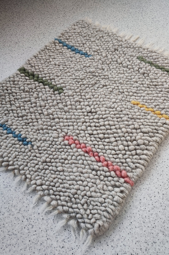 Buzhok Gray Rainbow Kids Rug in a cozy nursery