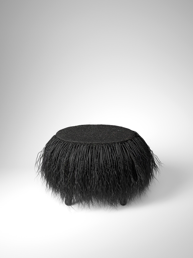 Minimalist black wool pouf on white background