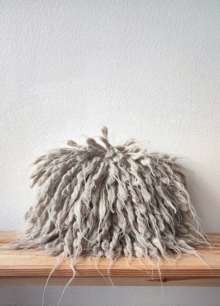 Artisanal wool pillow styled in minimalist living room